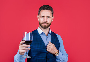 handsome man in formal wear hold glass of red wine for drinking, cheers