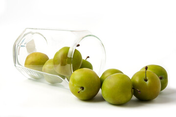 Green cherry plums in a glass cup