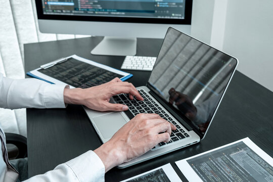Young Programmer working in software javascript computer in IT office, Writing codes and data code website and coding database technologies to find solution to problem