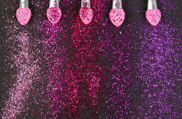 Colorful glitter crystals of eyelids makeup on black  background. Beauty and fashion concept. Macro shot. Close up. Flat lay.