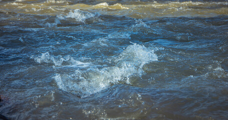 photo of the surface of the river. Water texture. Mountain river, spray and waves. Waves of green, blue and gray. Calm and tranquility. Fast flow of water,