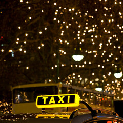 yellow taxi sign in front of many lights at night