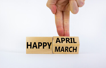 Symbol for the change from March to April. Businessman turns wooden cubes and changes words 'Happy March' to 'Happy April'. Beautiful white background, copy space. Happy April concept.