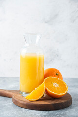 Glass pitcher of juice with slice of orange fruit