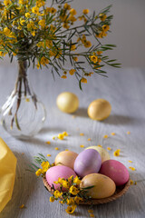 Easter eggs decorated with yellow flowers on a wooden table