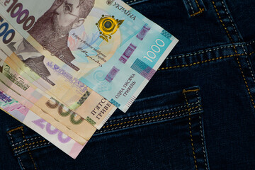 money in your pocket. Ukrainian hryvnia. 1000, 500, bills in a pants pocket. jeans trousers, a lot of money of different denominations in my pocket. business, trade or financial transactions.
