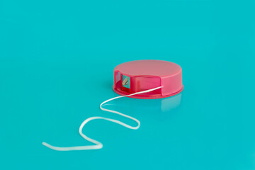 dental floss in a pink package close-up on a blue background. the concept of dental and oral care,...