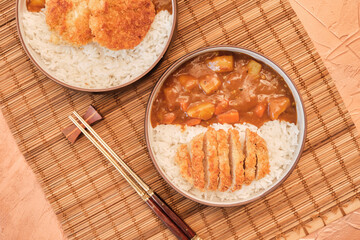 Top view Japanese curry rice topping with fried pork and vegetables in white and black plate with chopsticks. Curry rice Japanese food.