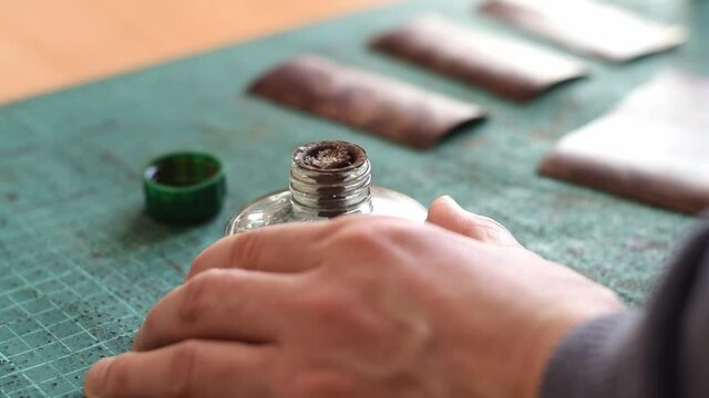 Heating the tool for working with the genuine leather on the fire of an alcohol lamp.Tanner's hands close-up, slow motion.Handmade leather manufactures.Hobby concept.