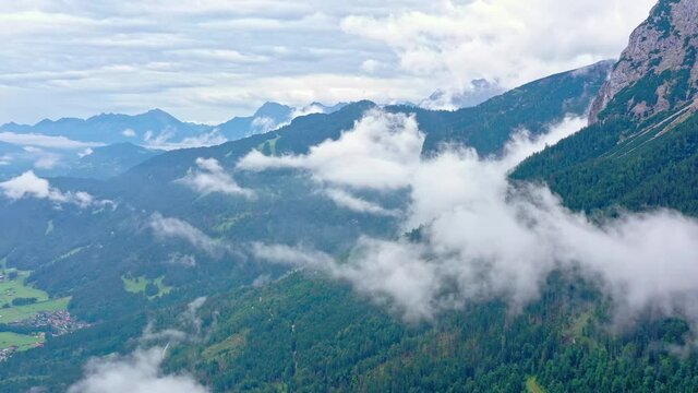 Over the mists, the drone flies over the tall green mountains