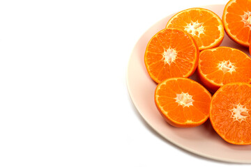 Whole and slice juicy fresh orange fruits in a plate