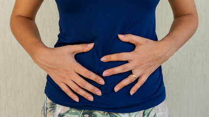 woman with hands on belly, probiotic and prebiotic foods for intestinal health, having stomach...