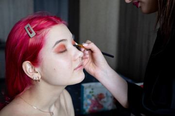 pink-haired girl, with three gold earrings, paint eyelids, close-up