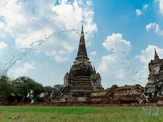 Fototapeta premium ancient pagoda (chedie) ruins of old Siam capital Ayutthaya with foreground water drop curve at Wat Phra Si Sanphet temple, famous place for travelling in Phra Nakhon Si Ayutthaya Province, Thailand 