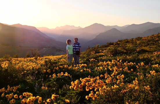 Happy couple in yellow flowers. Gentle monring light. Washington State. USA