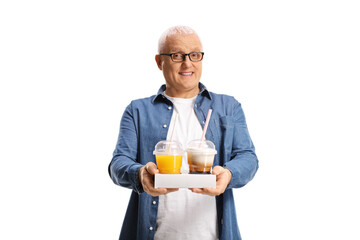 Mature man holding takeaway coffee and orange juice