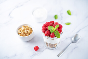 Raspberry Greek yogurt granola parfait in a glass