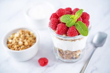 Raspberry Greek yogurt granola parfait in a glass