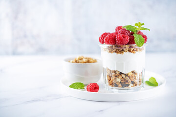Raspberry Greek yogurt granola parfait in a glass