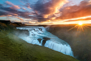 One of the most famous sights along Iceland's Golden Circle, Gullfoss Waterfall. Shot during the crack of sunrise illuminating the vibrant colors of the flowing water and fiery skies