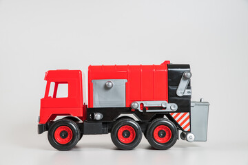 Plastic car. Toy model isolated on a white background. Red truck for the transport of garbage.