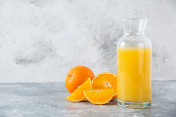Glass pitcher of juice with slice of orange fruit
