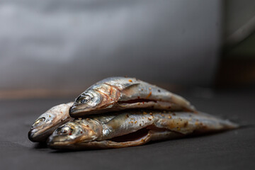 fish with spices lie for cooking on a gray background