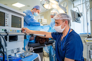 In the ICU. Doctor changes the parameters on artificial lung ventilation in modern operating room. Closeup.
