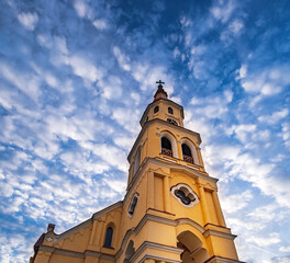 Fototapeta premium Holy Trinity Evangelical Church in Zvolen town, Slovakia. Panoramic scenic bottom view of old Lutheran church in main square of Zvolen, near Zvolen Castle under blue cloudy sky. Slovak architecture