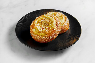 Vatrushka, cheese puff, cheese cake in black plate on white marble background