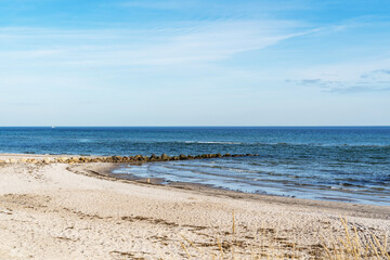 a ridge of stones go to the baltic sea on a sandy beach