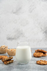 Cookies with organic peanuts and honey with glass of milk on marble background