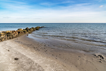 a ridge of stones go to the baltic sea on a sandy beach
