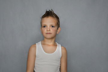 A boy in a white T-shirt looks ahead. 