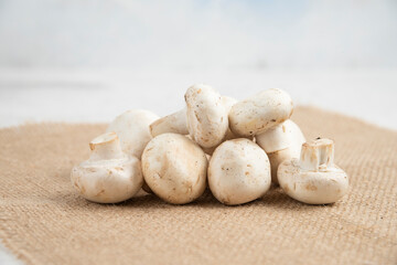 White mushrooms isolated on a piece of burlap