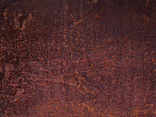 Uneven texture of cracked, weathered, faded, rotted flakes of rust on a sheet of iron. The background of a metal garage wall, the gate of an old abandoned factory. Shades of red, orange, brown.