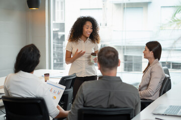 black business woman leading presentation for teammates in office or coworking space. .