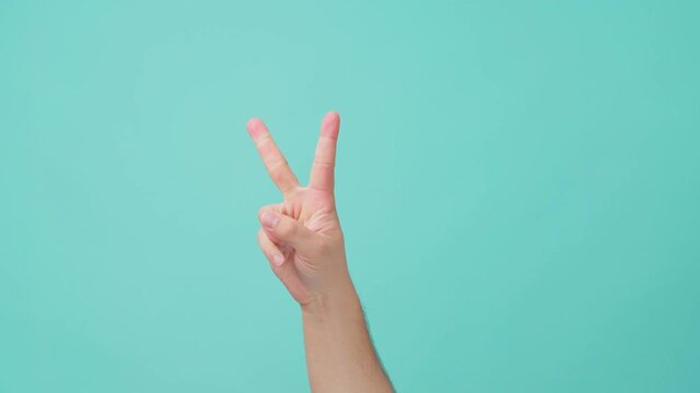 Close-up shot of human hand raising, with finger counting gesture.