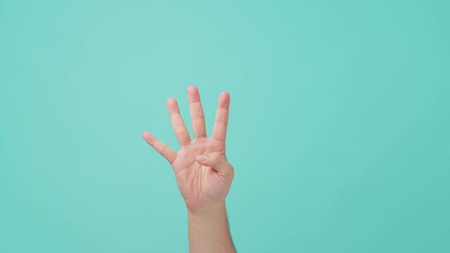 Close-up shot of human hand raising, with finger counting gesture.