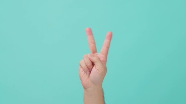 Close-up shot of human hand raising with V-sign on isolated background