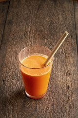A glass of fresh carrot juice with a bamboo straw - zero waste concept