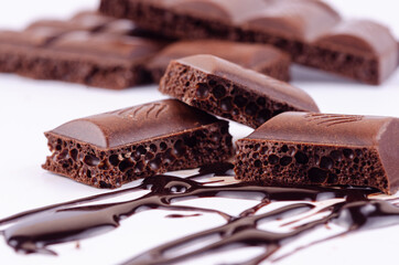 Background with chocolate lines pieces of chocolate bar on a light background