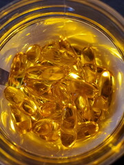 Top view of cod liver oil pills inside glass jar