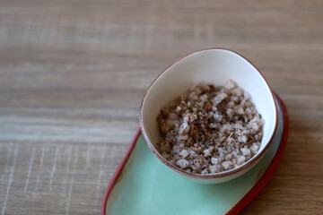 Bowl of sea salt mixed with Mediterranean herbs. Selective focus.