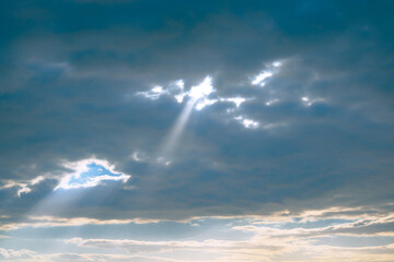 Naklejka na ściany i meble Sunlight beam in the dramatic clouds