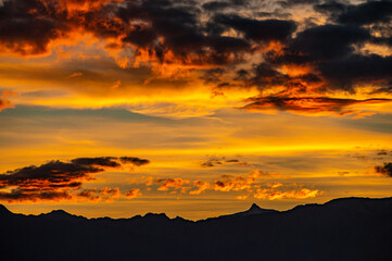 Sunset over the mountains. Dramatic sky at sunset with red, yellow and orange colors. Lausanne, Switzerland.