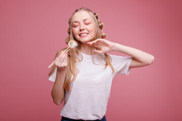 Happy woman with Sushi on a pink background
