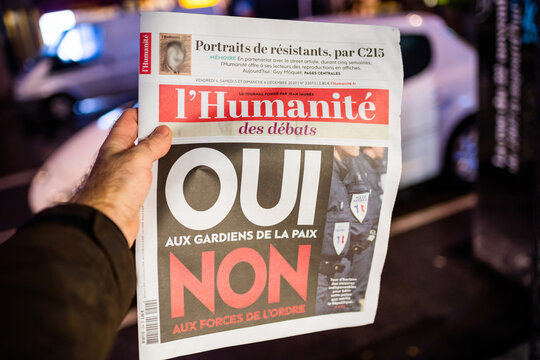 Strasbourg, France - Dec 4, 2020: Man holding l'Humanite newspaper at French press kiosk announcing the debate between yes or no for guardians for peace instead of police forces