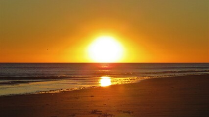 sunset on the beach with a reflection