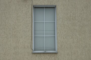 one white rectangular window on the brown concrete wall of the building